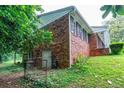 A brick exterior shows the side of the house with foliage growing close to the building at 3916 Ridgewood Se Dr, Smyrna, GA 30080