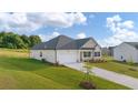 View of a single-story home with attached garage, side yard and manicured lawn with a beautiful blue sky at 648 Kimberwick Dr, Locust Grove, GA 30248