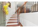 Inviting entryway features hardwood stairs, a decorative railing, and white wainscoting, creating an elegant ambiance at 1667 Wehunt Se Pl # 11, Smyrna, GA 30082