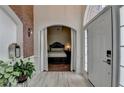 Charming foyer showcasing an arched doorway, view of a bedroom, light-colored wood-look floors, and a stylish lantern at 2678 Adair Trl, Dacula, GA 30019