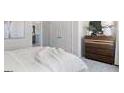Neutral primary bedroom showcasing a queen-sized bed and a wooden dresser, with a minimalist aesthetic at 5595 Rosehall Pl, Atlanta, GA 30349