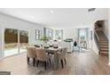 Open-concept living and dining area with hardwood floors, flowing into a modern kitchen and staircase at 5595 Rosehall Pl, Atlanta, GA 30349