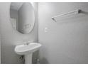 Powder room featuring a pedestal sink, a round mirror, and neutral wall color at 1341 Rogers Trce, Lithonia, GA 30058