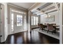 Elegant dining room featuring coffered ceilings, hardwood floors, and a stylish chandelier at 7575 Old Camp Lndg, Cumming, GA 30040