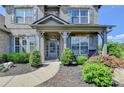 Inviting covered front porch with gray columns and manicured landscaping at 7575 Old Camp Lndg, Cumming, GA 30040