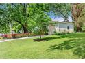 Side yard featuring green grass, flowerbeds, and a driveway leading up to an attached garage at 2364 Woodside Way, Atlanta, GA 30341