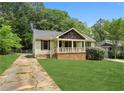 Quaint single-story home featuring a well-maintained lawn and a cozy front porch at 2074 Hilburn Se Dr, Atlanta, GA 30316