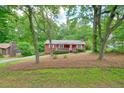 Red home nestled among mature trees and lush greenery, offering a serene and private setting at 2900 Country Nw Ct, Kennesaw, GA 30152