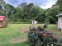 Expansive backyard featuring lush greenery, a storage shed, privacy landscaping, and room for outdoor activities at 483 Glen Terrace Rd, Auburn, GA 30011