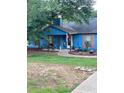 Charming blue home features a cozy front porch, landscaped garden bed, and inviting curb appeal at 483 Glen Terrace Rd, Auburn, GA 30011