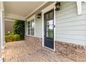 Covered front porch showcases brick accents and a black front door at 2222 Haventree Ct, Lawrenceville, GA 30043