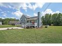Blue two-story home with well-manicured front lawn, front porch, and driveway on a sunny day at 37 Faithful Dr, Temple, GA 30179