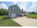 Inviting blue two-story home featuring a one-car garage, covered porch, and a well-kept lawn at 37 Faithful Dr, Temple, GA 30179