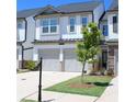 Charming townhome with a two-car garage, a well-manicured lawn, and gray and white accents at 5790 Thornton Dr, Cumming, GA 30028