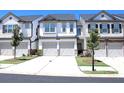 Charming townhome with a two-car garage, a well-manicured lawn, and gray and white accents at 5790 Thornton Dr, Cumming, GA 30028