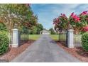 Gated driveway leading to a beautiful home with mature trees and landscaping at 3898 Bay Creek Rd, Loganville, GA 30052