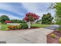 Inviting entrance with flowering trees, a white picket fence, and lush landscaping at 3898 Bay Creek Rd, Loganville, GA 30052