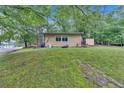 Spacious front yard featuring a cozy house and mature trees at 5400 Kings Camp Rd Se #C1 Se Rd, Acworth, GA 30102