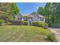 Attractive front exterior featuring a stone facade, manicured bushes, and a sloped front lawn at 6790 India Ln, Cumming, GA 30041