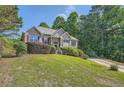 Inviting front exterior showcasing a well-kept lawn, mature trees, and a cozy home design at 6790 India Ln, Cumming, GA 30041