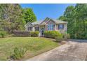 Beautiful home exterior featuring a front lawn, mature trees, and charming architectural details at 6790 India Ln, Cumming, GA 30041