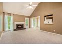 Spacious living room with plush carpeting, a fireplace, vaulted ceiling and lots of natural light from multiple windows at 90 Camden Woods Pl, Dallas, GA 30157