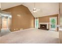 Inviting living room featuring a fireplace, plush carpeting, and a door to the backyard allowing for seamless indoor-outdoor living at 90 Camden Woods Pl, Dallas, GA 30157