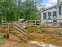 Beautifully landscaped backyard with terraced garden beds and wooden stairs at 1482 Pinebark Ct., Grayson, GA 30017