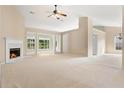 Open-concept living area with neutral walls, fireplace, and large windows overlooking the backyard at 2620 Matlin Way, Buford, GA 30519