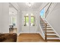 Elegant foyer with hardwood floors, staircase, and a view into the adjacent dining room at 3298 Alcovy Club Ct, Dacula, GA 30019