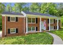 Charming two-story brick home featuring classic architecture, black shutters, and a welcoming front porch at 4331 E Kings Point Circle, Dunwoody, GA 30338