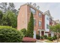 Brick townhome showcasing its architectural details, landscaping, and attached garage at 7812 Kiverton Pl, Atlanta, GA 30350