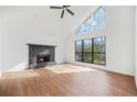Bright living room featuring high ceilings, a striking stone fireplace, and large windows offering ample natural light at 3813 Nowlin Nw Rd, Kennesaw, GA 30144