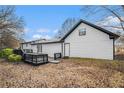 This home offers a spacious wooden deck in a backyard with mature trees and leafy groundcover at 441 Village Way, Lawrenceville, GA 30046
