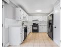 Traditional kitchen with white cabinets and black appliances offers ample countertop space and storage at 441 Village Way, Lawrenceville, GA 30046