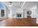 Sunlit living room features hardwood floors, a cozy fireplace, and detailed ceiling trim and a large window at 441 Village Way, Lawrenceville, GA 30046