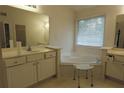Bright bathroom with a corner tub, dual vanities and natural light from a window at 442 John Stewart Pl, Suwanee, GA 30024