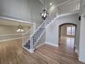 Bright open foyer featuring wood floors, a grand staircase, and decorative lighting at 7910 Tintern Trce, Duluth, GA 30097