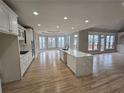 Modern open kitchen features an island, stainless appliances, hardwood floors, and abundant natural light at 7910 Tintern Trce, Duluth, GA 30097