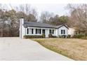 Inviting home with an expansive driveway, black shutters, and mature landscaping at 2172 Red Rose Ln, Loganville, GA 30052