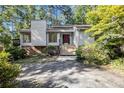 Inviting home exterior features a red door, brick foundation, and mature landscaping at 2830 Jodeco Dr, Jonesboro, GA 30236