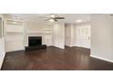 Spacious living room with a fireplace, built-in shelves, and beautiful hardwood floors at 4902 Cedar Se Ct, Conyers, GA 30094