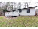 Home's backyard featuring a deck, lawn and wooded surrounding at 3436 Lake Monroe Rd, Douglasville, GA 30135