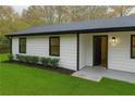 Side view of the home, showcasing the entrance, manicured lawn, and window details at 3436 Lake Monroe Rd, Douglasville, GA 30135