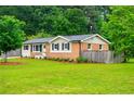 Quaint home featuring a brick and siding exterior, complemented by a spacious lawn and mature trees at 4529 Lakeview Dr, Powder Springs, GA 30127