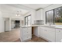 Well-lit kitchen with white cabinets, granite countertops, and a view into the living area at 5444 Wylstream, Norcross, GA 30093