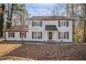 Traditional two-story home with black shutters, surrounded by trees in a suburban setting at 7935 Sweetwater Dr, Douglasville, GA 30135