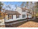 Traditional two-story home with black shutters and pathway surrounded by fall foliage at 7935 Sweetwater Dr, Douglasville, GA 30135