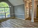 Open-concept living room featuring stylish flooring, trim, and a large window for lots of natural light at 110 Orleans Blvd, Mcdonough, GA 30253