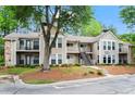 Charming multi-Gathering building featuring beige siding, stone accents, balconies, and scenic greenery at 1214 Lake Pointe Cir, Roswell, GA 30075